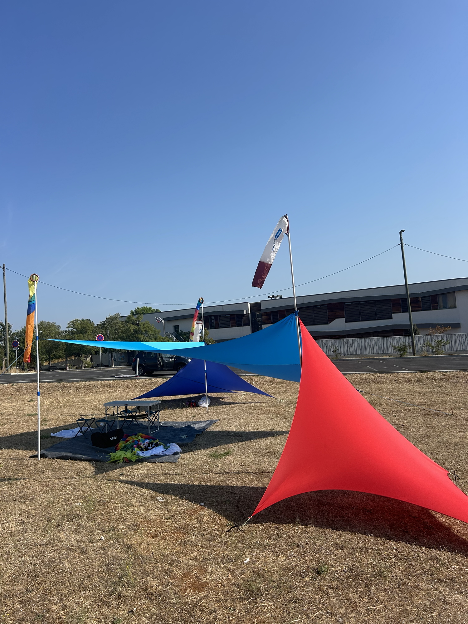 Stand en tissu lycra bleu et rouge avec des manches à air le tout sur le terrain de vol libre avec l'école François Mitterrand.